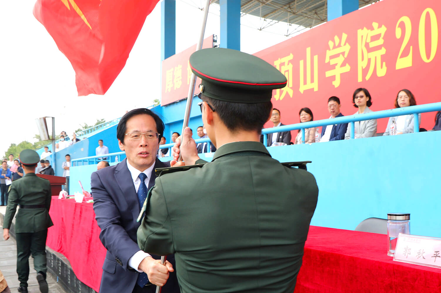 党委书记华小鹏向军训师授旗(摄影常钰河)