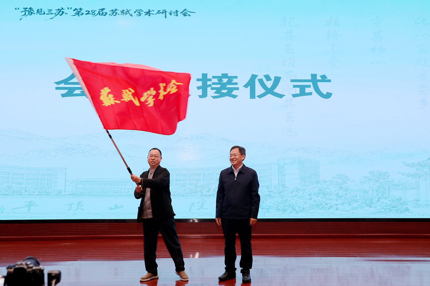 平顶山学院校长郭秋平将研讨会会旗移交第29届承办单位代表、眉山三苏祠博物馆馆长陈仲文 常钰河